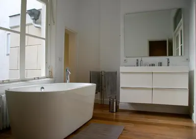 a white bathroom with a tub and a sink at Mokum Suites in Amsterdam
