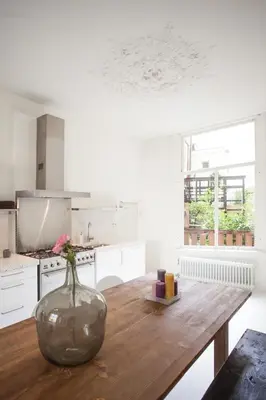 a kitchen with a wooden table with a vase on it at Mokum Suites in Amsterdam