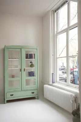 a green cabinet in a white room with a window at Mokum Suites in Amsterdam