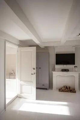 a white room with a door and a television at Mokum Suites in Amsterdam
