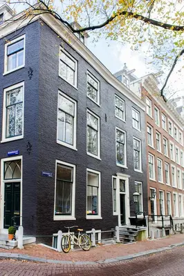 a black building with two bikes parked in front of it at Mokum Suites in Amsterdam