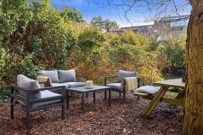 a patio with a couch and chairs and a table at Casa Beach with free parking and garden in Zandvoort