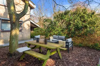a picnic table and chairs next to a tree at Casa Beach with free parking and garden in Zandvoort