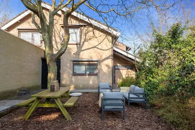 a picnic table and chairs in front of a house at Casa Beach with free parking and garden in Zandvoort