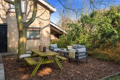 a picnic table and chairs next to a building at Casa Beach with free parking and garden in Zandvoort