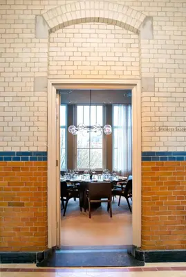 a dining room with a table in a brick wall at Pillows Grand Boutique Hotel Maurits at the Park - Small Luxury Hotels in Amsterdam