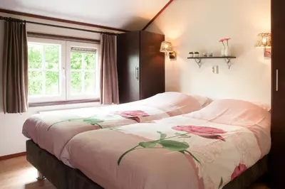 a bedroom with two beds and a window at Mariahoeve-Logies #Polderhuisje in Woubrugge