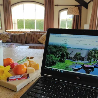 a laptop computer sitting on top of a table at Mariahoeve-Logies #Polderhuisje in Woubrugge