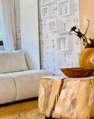 a living room with a couch and a wooden stump coffee table at Casa De Palmas - Tiny house in Alkmaar