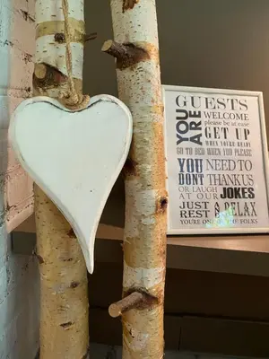 a heart hanging on a tree next to a sign at Casa De Palmas - Tiny house in Alkmaar
