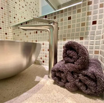 a towel sitting next to a sink in a bathroom at Casa De Palmas - Tiny house in Alkmaar