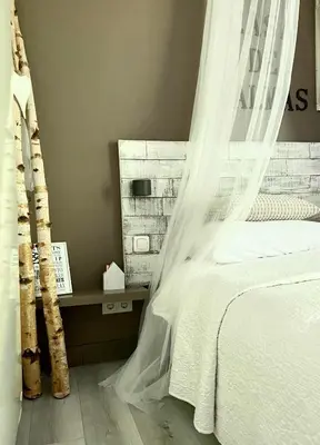 a bedroom with a bed with a mosquito net at Casa De Palmas - Tiny house in Alkmaar