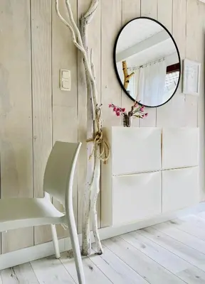 a white dressing room with a chair and a mirror at Casa De Palmas - Tiny house in Alkmaar
