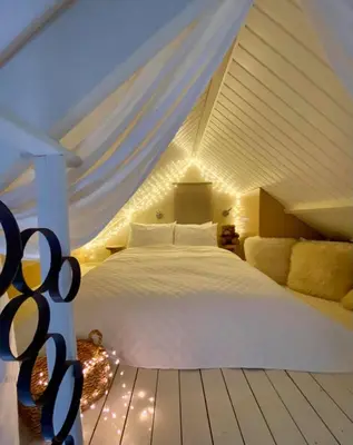 a bedroom with a white bed in a attic at Casa De Palmas - Tiny house in Alkmaar