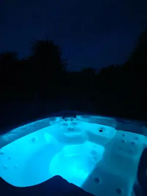 a jacuzzi tub lit up in the dark at Big Family villa 12p big garden with bathtub and jacuzzi in Zeewolde