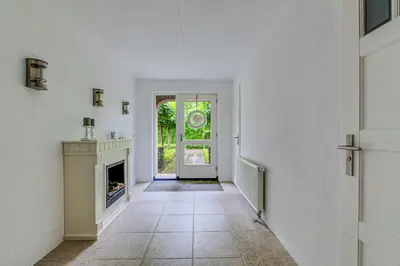 an empty hallway with a door and a fireplace at Big Family villa 12p big garden with bathtub and jacuzzi in Zeewolde
