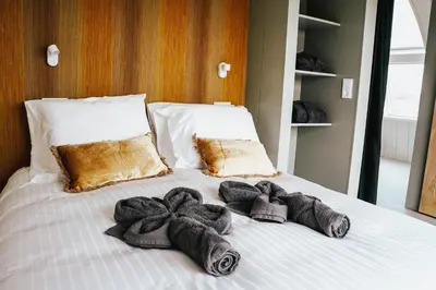 a white bed with towels on top of it at Penthouse Witsand Zeezicht in Egmond aan Zee