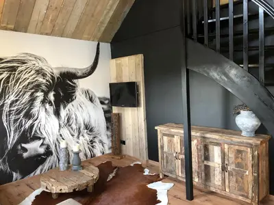 a room with a painting of a cow on the wall at Logement Bilderdam in Leimuiden