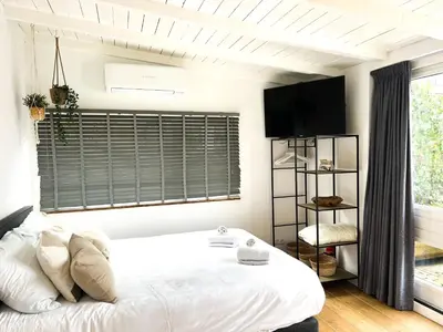a bedroom with a white bed and a window at Little Beach House in Zandvoort