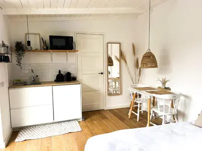 a kitchen and dining room with a table and a bed at Little Beach House in Zandvoort