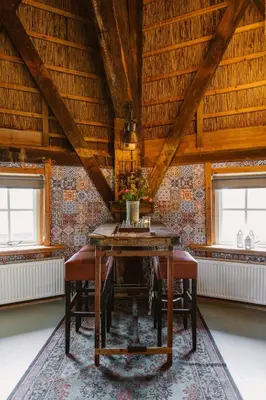a dining room with a wooden table and chairs at De Molen van Egmond by Droomvilla in Egmond aan den Hoef