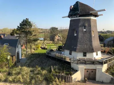 a house with a windmill on top of it at De Molen van Egmond by Droomvilla in Egmond aan den Hoef
