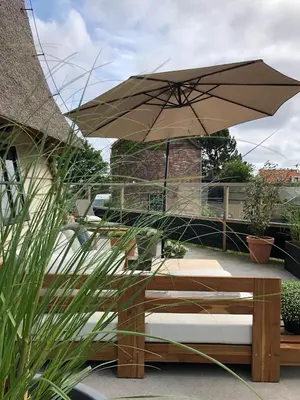 a patio with a bench and an umbrella at De Molen van Egmond by Droomvilla in Egmond aan den Hoef