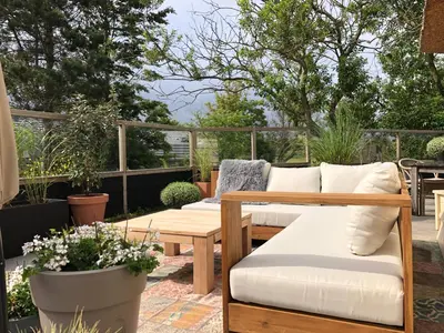 a patio with couches and a table and some plants at De Molen van Egmond by Droomvilla in Egmond aan den Hoef