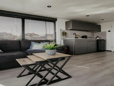 a living room with a couch and a table at Luxury Houseboat Getaway in Uitgeest
