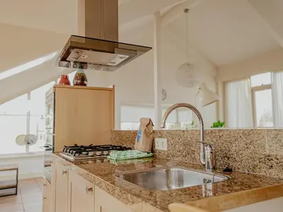 a kitchen with a sink and a stove at Penthouse with Lake Views in Uitgeest