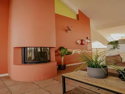 a living room with a fireplace and a table at Penthouse with Lake Views in Uitgeest