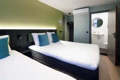 a hotel room with two beds and a bathroom at Ciao Papa Hotel Amsterdam Central Station in Amsterdam