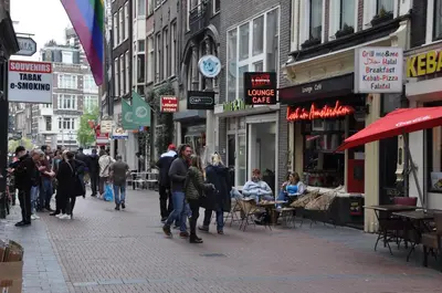 a group of people walking down a busy city street at Ciao Papa Hotel Amsterdam Central Station in Amsterdam