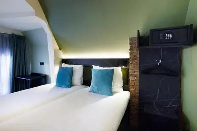 a hotel room with two beds with blue pillows at Ciao Papa Hotel Amsterdam Central Station in Amsterdam