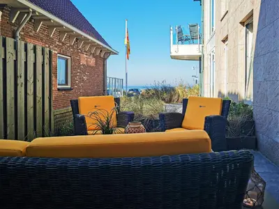 a group of chairs and a couch on a patio at De Platvis in Egmond aan Zee
