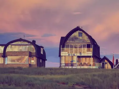 a house with two domes on top of a field at De Platvis in Egmond aan Zee