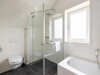 a bathroom with a shower and a toilet and a sink at De Platvis in Egmond aan Zee