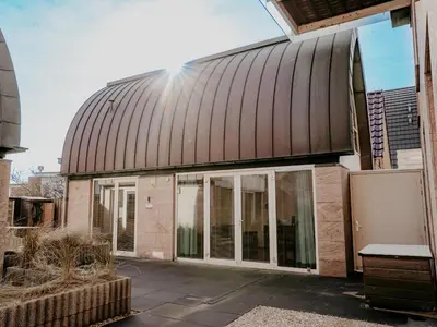 an exterior view of a building with sliding glass doors at De Platvis in Egmond aan Zee