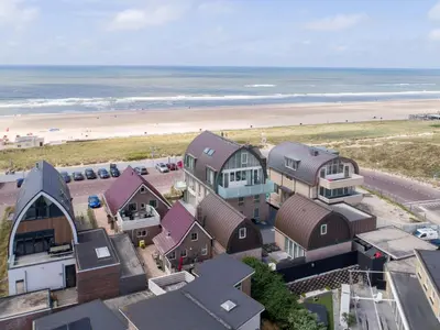 an aerial view of a beach with houses and the ocean at Zeebaars in Egmond aan Zee