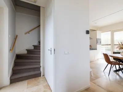 a staircase in a home with white walls and a hallway at Zeebaars in Egmond aan Zee