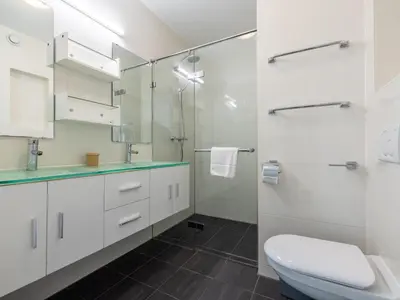 a white bathroom with a toilet and a shower at De Kreeft in Egmond aan Zee