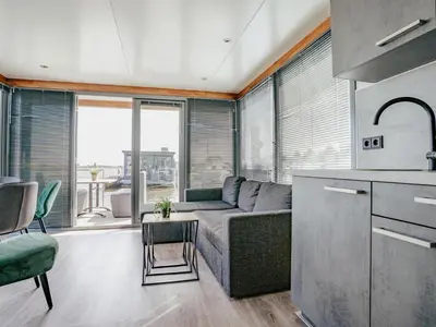 a living room with a couch and a table at Tiny houseboat Uitgeest I in Uitgeest