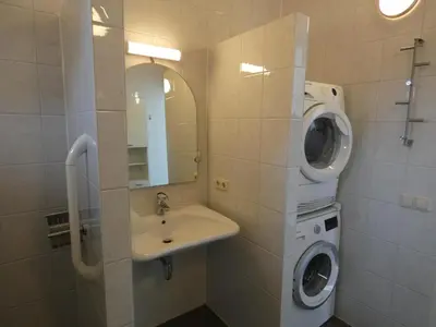 a bathroom with a washing machine and a sink at Het Kraaijennest Miva in Uitgeest