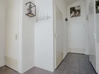 a hallway with two white doors and a tile floor at Het Kraaijennest Miva in Uitgeest