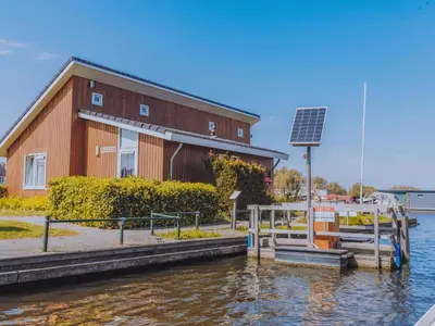 a building with a solar panel next to the water at Het Kraaijennest Miva in Uitgeest
