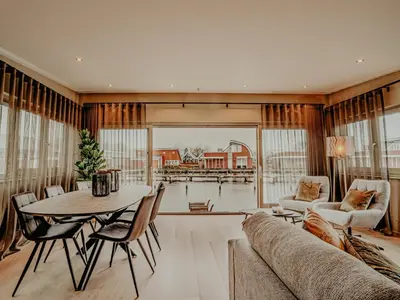 a living room with a table and a couch at Woonark De Woude in Uitgeest