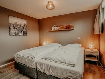 a bedroom with a bed and a shelf on the wall at Woonark De Woude in Uitgeest