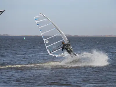 a man is windsurfing in the ocean on the water at Woonark De Woude in Uitgeest
