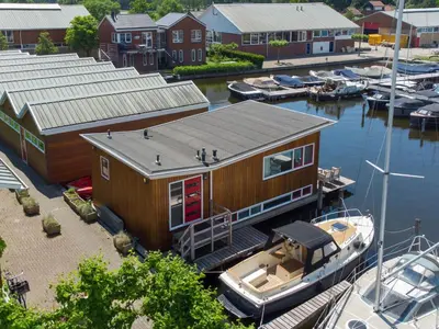 a small boat is docked at a marina at Woonark De Woude in Uitgeest