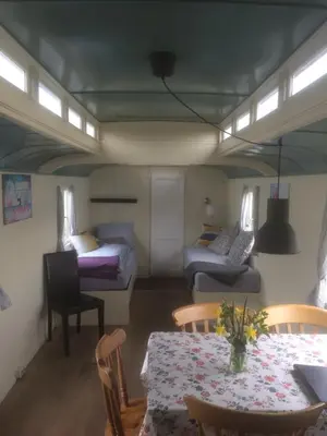 a room with a table and a bed and a table and chairs at Gypsy Waggon - A villa on wheels in Amsterdam